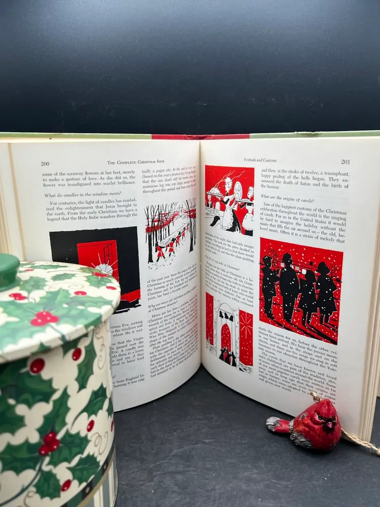 Vignette #5 Includes A Vintage Hard Cover ‘The Complete Christmas Book’ 
Published By Franklin Watts, Illustrated By William Ronin
A Vintage Christmas Tin. Santa’s Workbench Holly And Berry Pattern 
1999 Jo-Ann Stores, Inc. 
And An Adorable Cardinal Figurine.