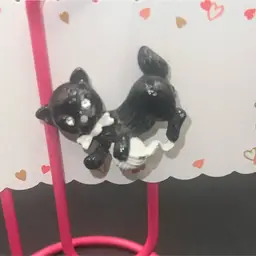 Vintage Gerry's black kitten brooch, featuring the cat wearing a white bow tie and playing with a white ball of yarn.