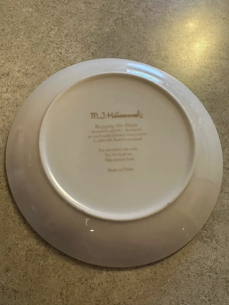 Porcelain collector plate titled
'Begging His Share' by M.I. Hummel for Goebel