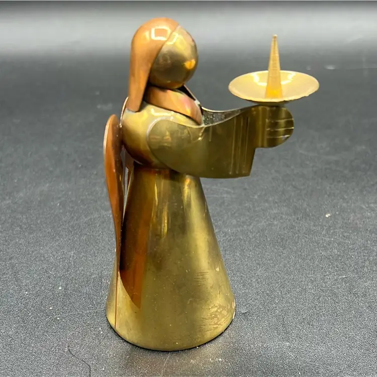 Vintage angel candle holder, likely handmade from brass and copper, often associated with holiday decor and Mexican craftsmanship.