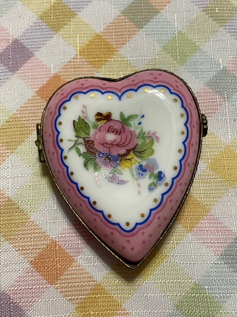 A French Limoges porcelain heart-shaped trinket box with "Je t'aime" inscription.