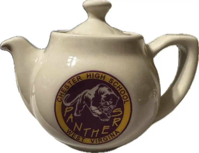 Vintage white ceramic teapot featuring a round seal or logo on the front.