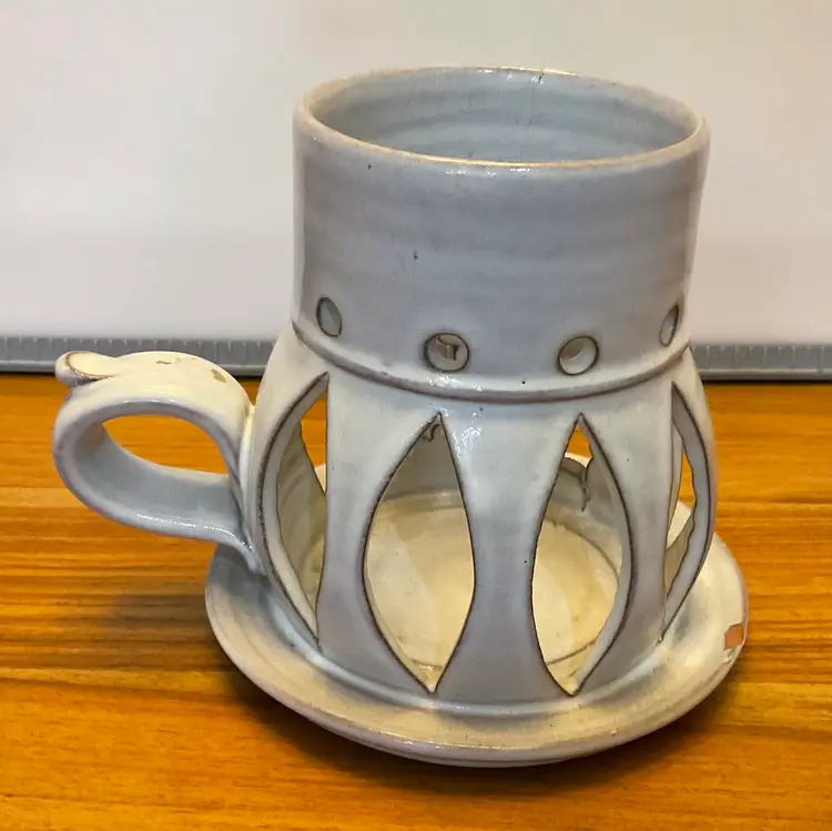 #01 Lovely 5” tall soft white candle holder / lantern with holly leaves and berries and candle on front, marquis cuts on back and stylized handle. Signed on the bottom