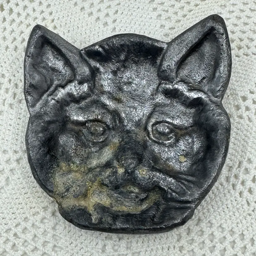 Vintage cast iron decorative dish shaped like a cat's face.
