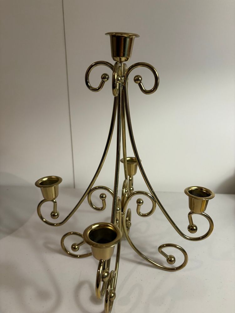 Vintage gold metal candelabra with a scrollwork design and five candle cups