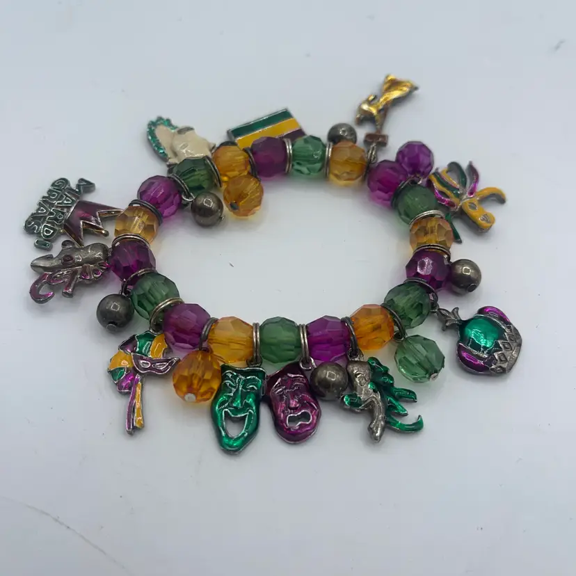 Mardi Gras Stretch Bracelet With 10 Different Charms On It. It Is Approximately 7 Inches Before The Stretch.