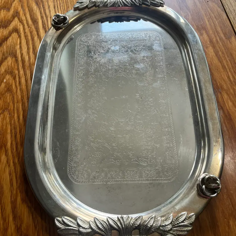 Ornate silver-plated oval serving tray with rose and laurel handles. 24x14”