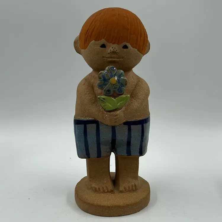 Vintage Lisa Larson Adam 2 Gustavsberg Sweden Mid Century Modern Red Haired Freckled Nose Boy w/ Blue Flower And Blue Stripped Shorts.  Minor Scuffing And Paint Loss On Red Hair See Photos.  7.75” T