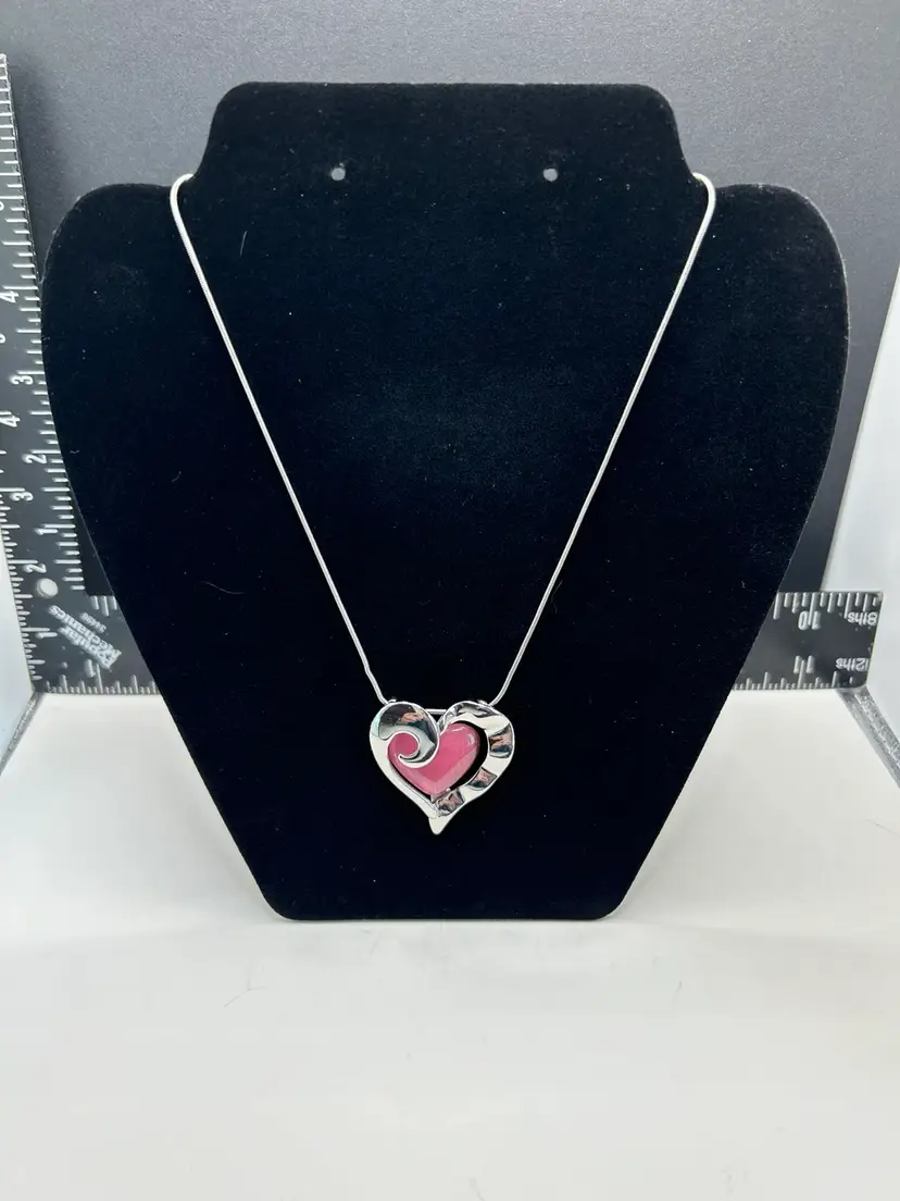 Pink Heart-Shaped Pendant On A Silver Toned Chain. The Pink Heart Is Surrounded By Scalloped Edge, Silver Tone, Heart Sculpture  This Is Unbranded  Excellent Condition.  I Know It Looks Like There’s Some Tarnish On It But That’s Actually The Scallop Wavy Edges So It’s A Reflection.