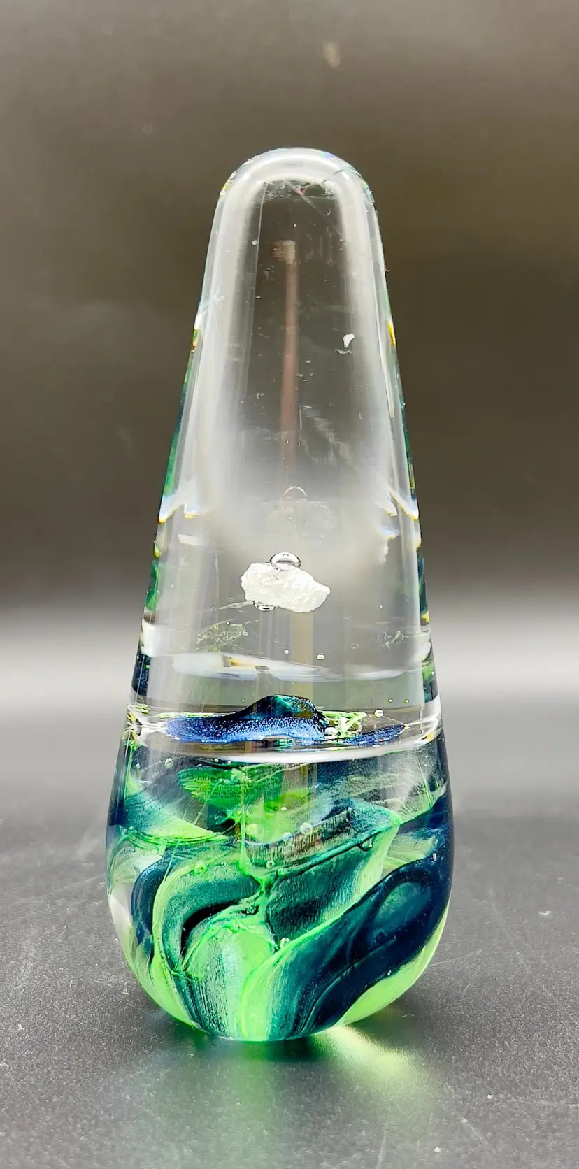 Vintage hand-blown narrow conical art glass paperweight with emerald green and teal green swirl encased at the base.
