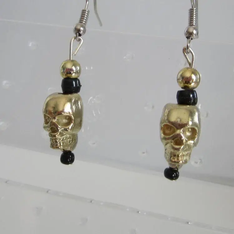 Gold metal skull earrings with beaded accents
