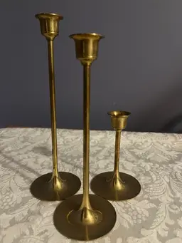 A vintage set of three brass taper candle holders.  8" ,  7 " and  4 "