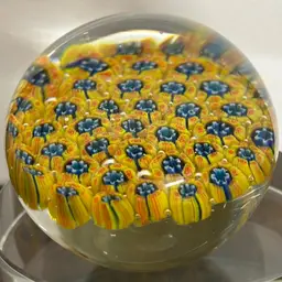 Murano glass paperweight featuring a millefiori (thousand flowers) design with yellow and blue colors