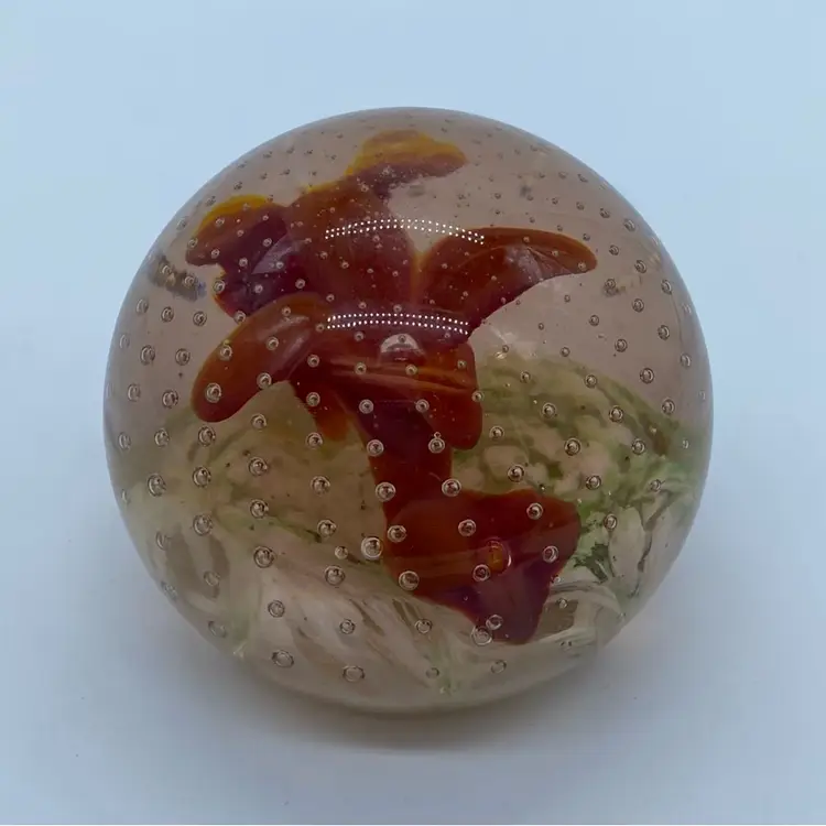 #0054 glass paperweight with a red floral design and controlled bubbles.