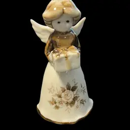 A vintage porcelain angel bell figurine holding a gift with floral decoration. Christmas 3.5”