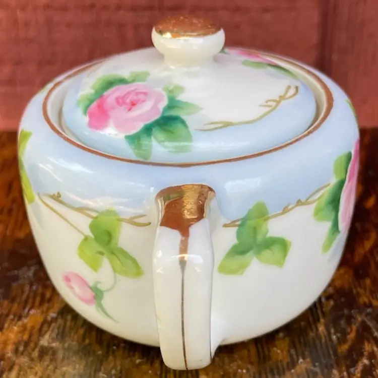Antique Nippon Hand Painted Sugar Bowl With Lid And Spoon. White & Blue With Pink Roses & Greenery Motif With Gold Gilt. 2.5”h.