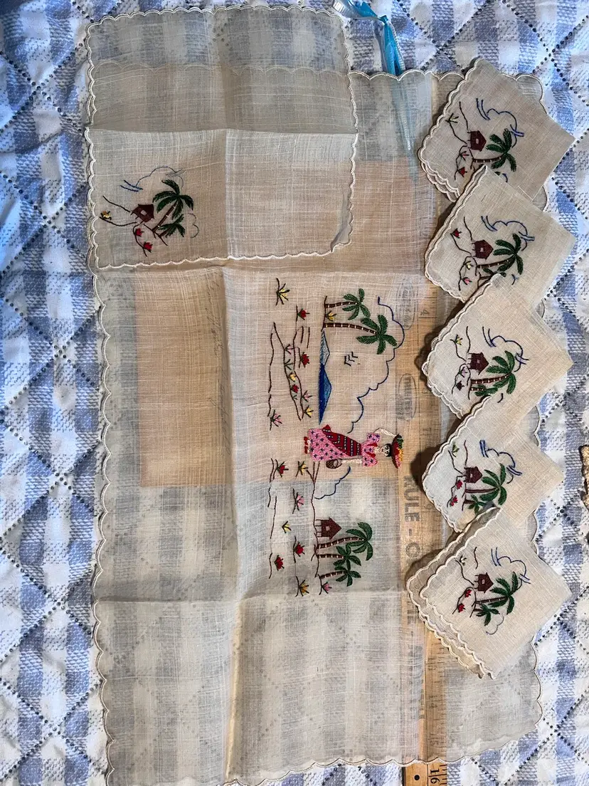 #1033-B Vintage Tropical Design Embroidered Linen Table Dresser Topper With Scalloped Edges and Matching Napkin Set
Possibly from Japan/Asian Inspired
Embroidered Palm Trees, Mountains, Flowers, a Lady Carrying a Basket, and a Hut