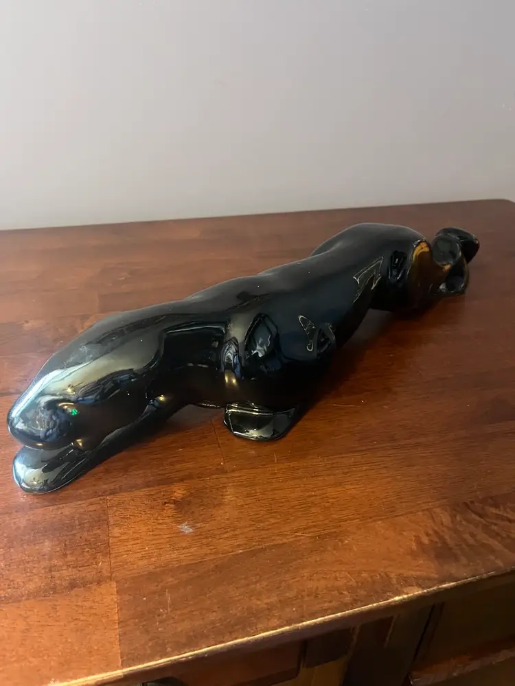 A glossy black ceramic panther figurine in a stalking pose. 19”
