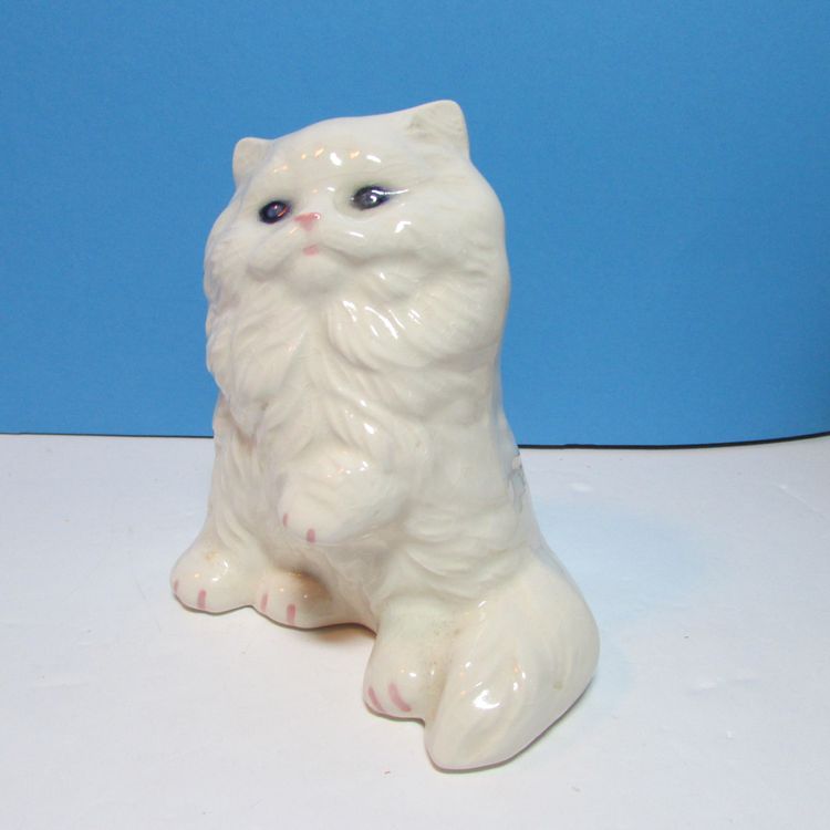 vintage white ceramic Persian kitty cat figure sitting with blue eyes paw up