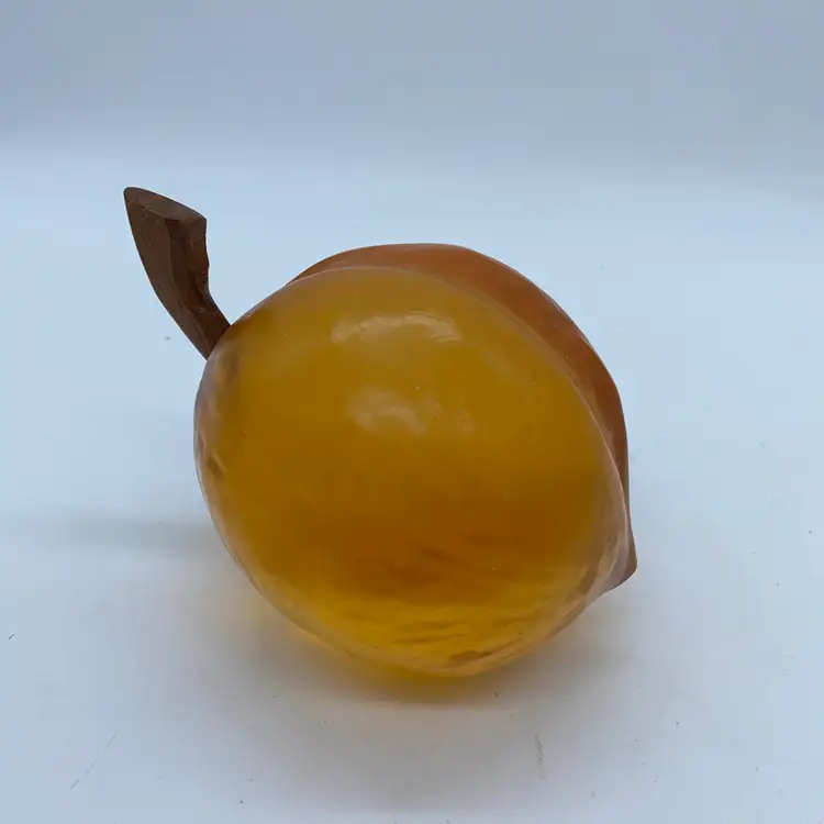 #0006 A mid-century Lucite paperweight shaped like a realistic peach with a brown stem.