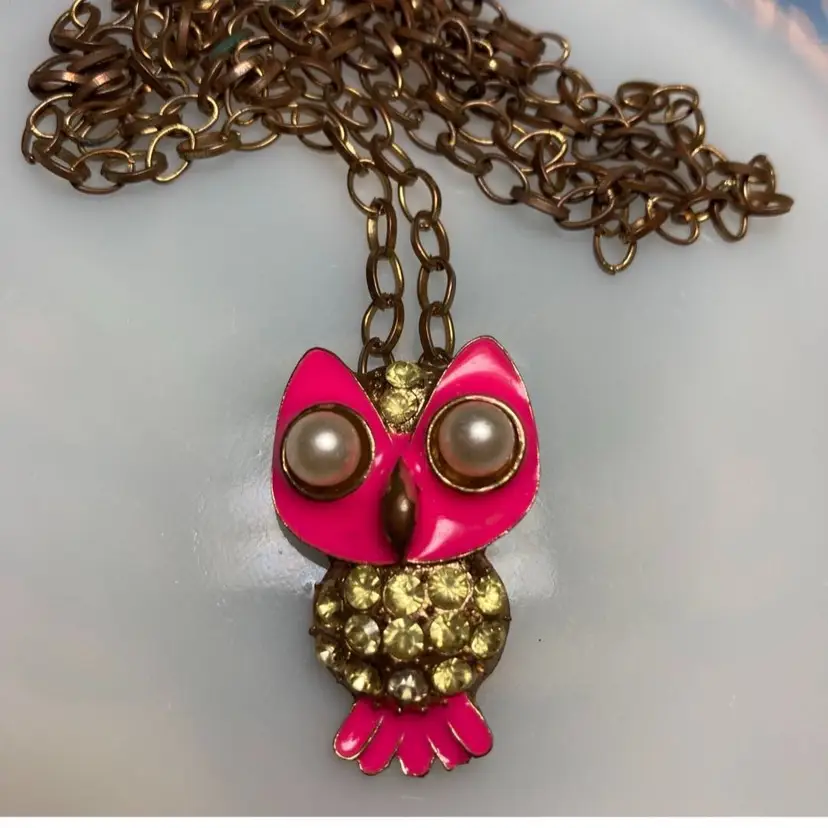 Vintage Hot Pink Owl Necklace - 
32” Unusual Brass Chain - 
Faux Pearl Eyes - Gold Tone - Light Green Faceted Crystals In A Pave Setting In The Body - Light Green Faceted Crystals Up Between The Eyes - The Hot Pink Enamel Is In Perfect Condition, No Chipping - NO CRYSTALS MISSING - The Chain Has Some Patina & Wear From Use & Age 
Owl Height:  1”
Owl Width:  .75” (3/4”)