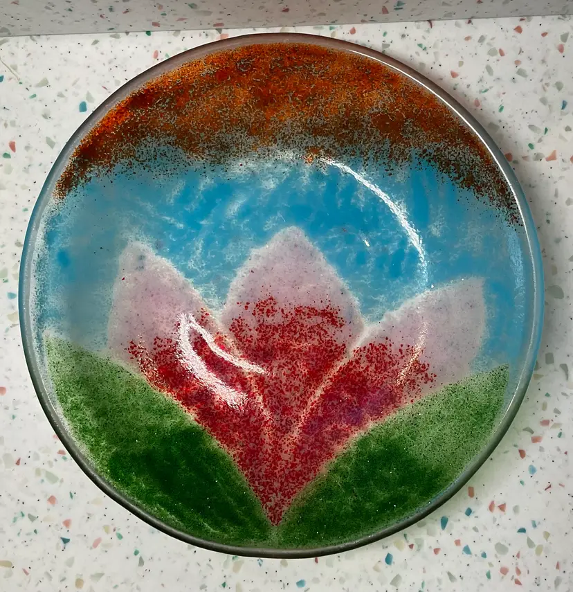 Fused glass bowl, 7 3/4” round and 3/4” deep.  Summer has arrived with sunshine, blue skies, tulip, and grass. All the summer feels in one piece.