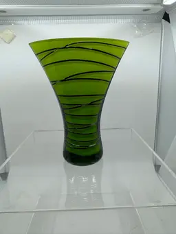 Hand-blown green art glass vase with black linear decoration.