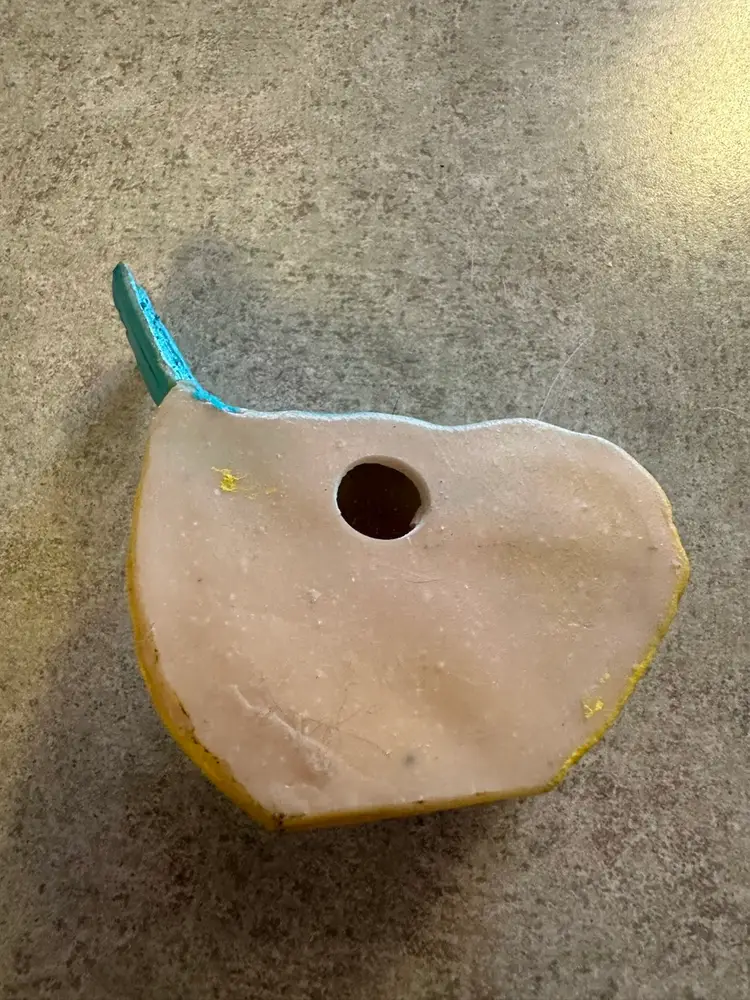 Resin bird figurine in blue and yellow.