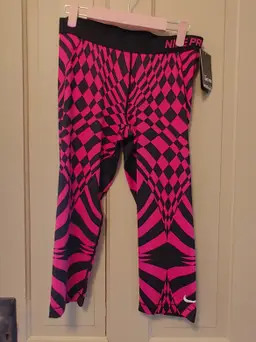 Bottoms- Brand: Nike Pro. Size Large. NWT. Retail $50. Black & pink capris. 80% polyester, 20% spandex. No callouts.