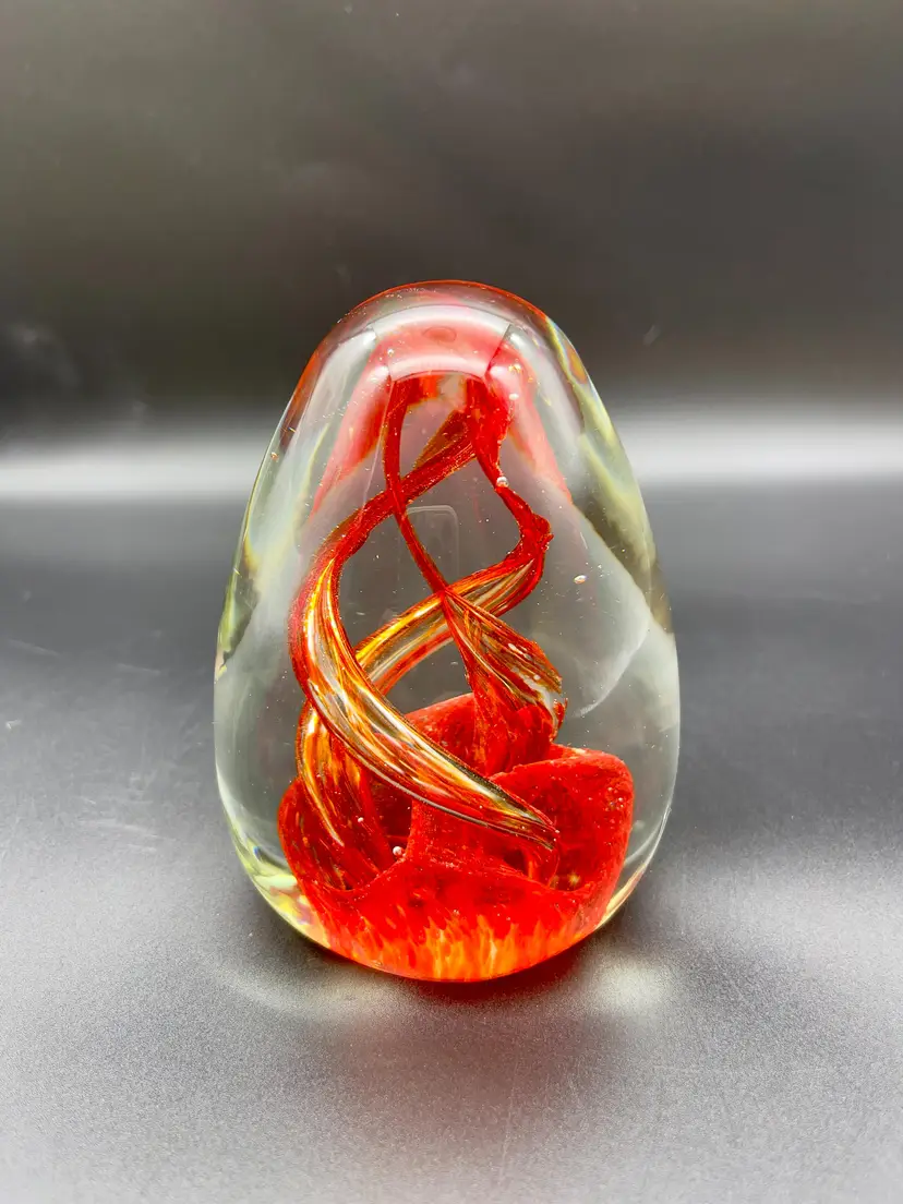 Vintage hand-blown art glass teardrop paperweight with orange swirl.