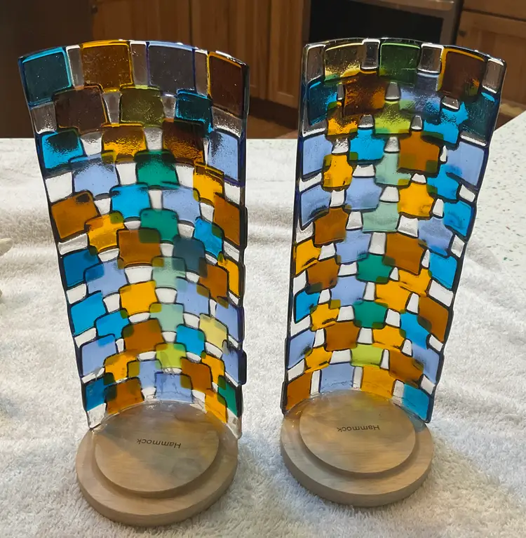 #01 Two fused glass candle holders. 9.5” tall and 5” wide the fused pieces are attached to wood bases 3 3/4” round. Will accommodate large pillar candles.