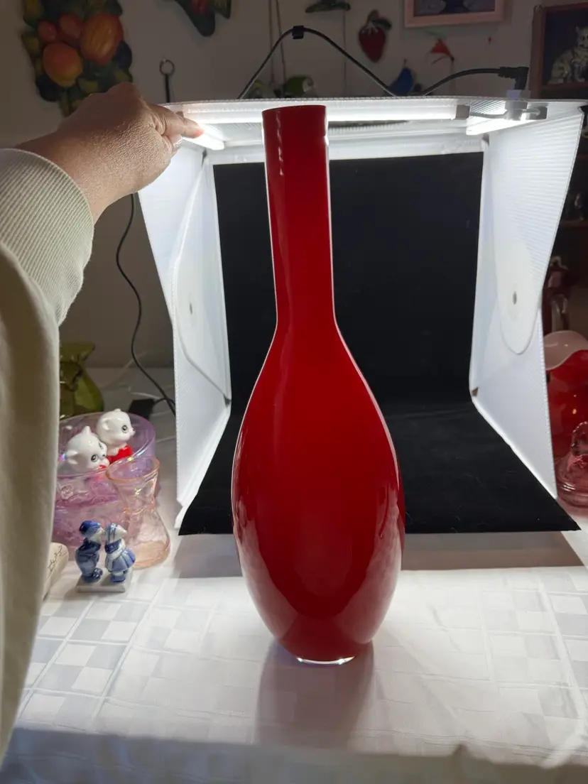 A 15 Inch tall, slender, red, White Casing, art glass vase with a bulbous base.