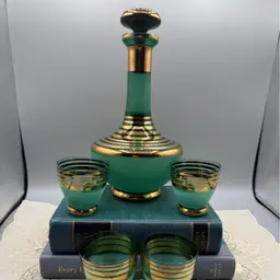 Mid-Century Modern "genie" style decanter with a tapered neck and matching bulbous stopper, paired with four matching cordial or shot glasses.
 10x4”
