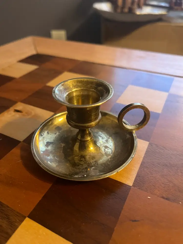 A vintage brass chamberstick candle holder with a drip tray and handle. - Has Patina, Made In India Sticker On Bottom- 2 Inches High