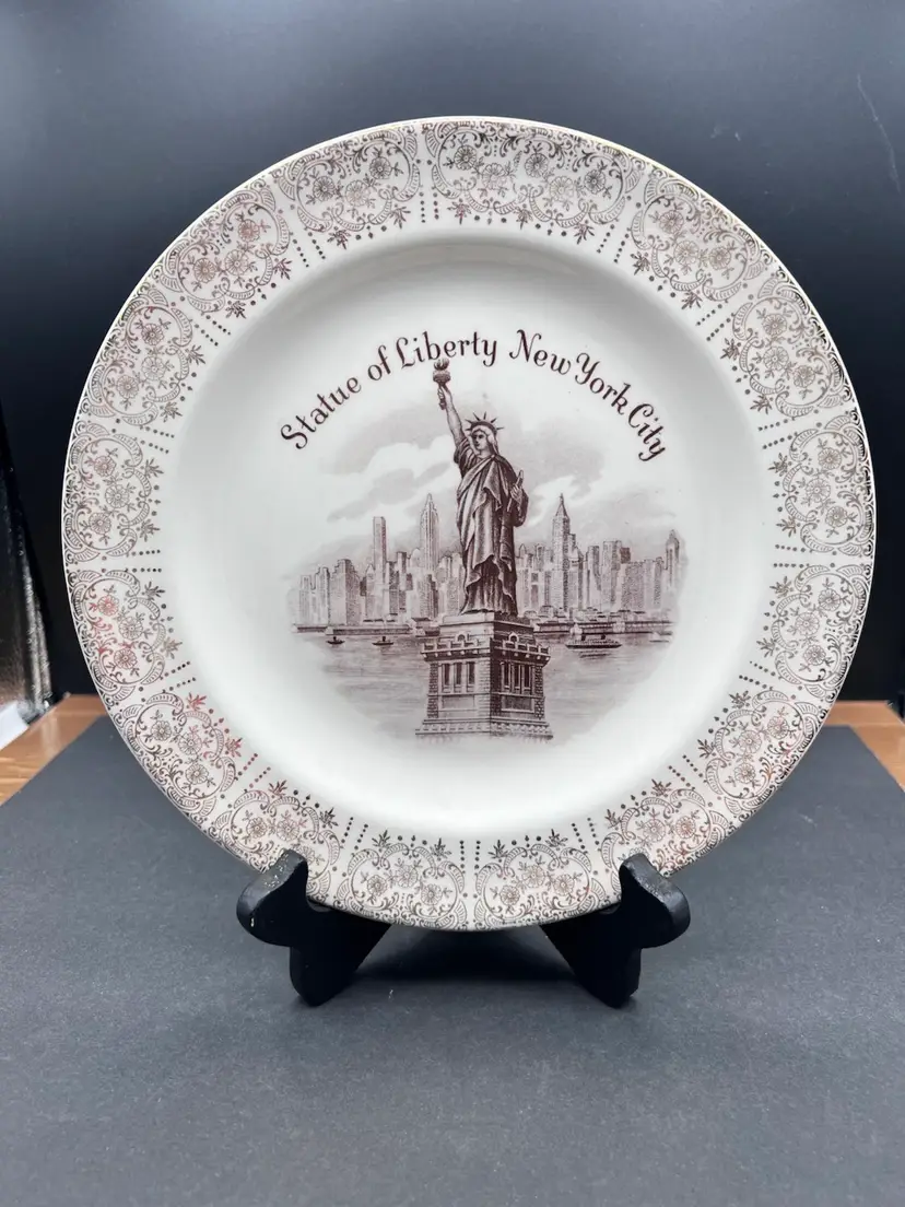 Vintage Collector Plate Depicting The Statue Of Liberty
Beautiful Cream Color With Gold Leaf Lace Design Around The Rim