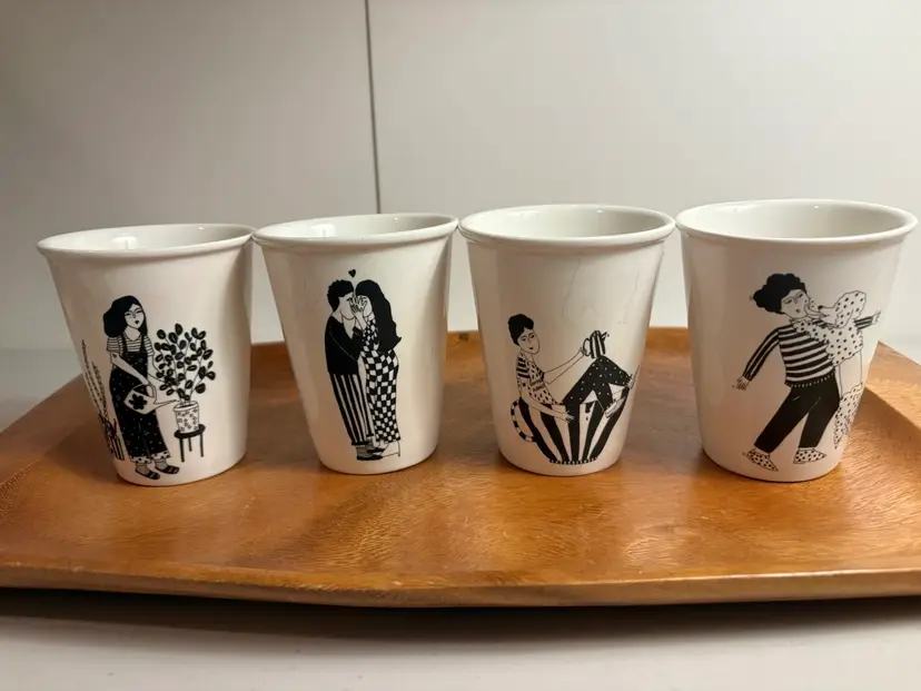 Helen B Set Of 4 porcelain cups featuring various black line-art illustrations.