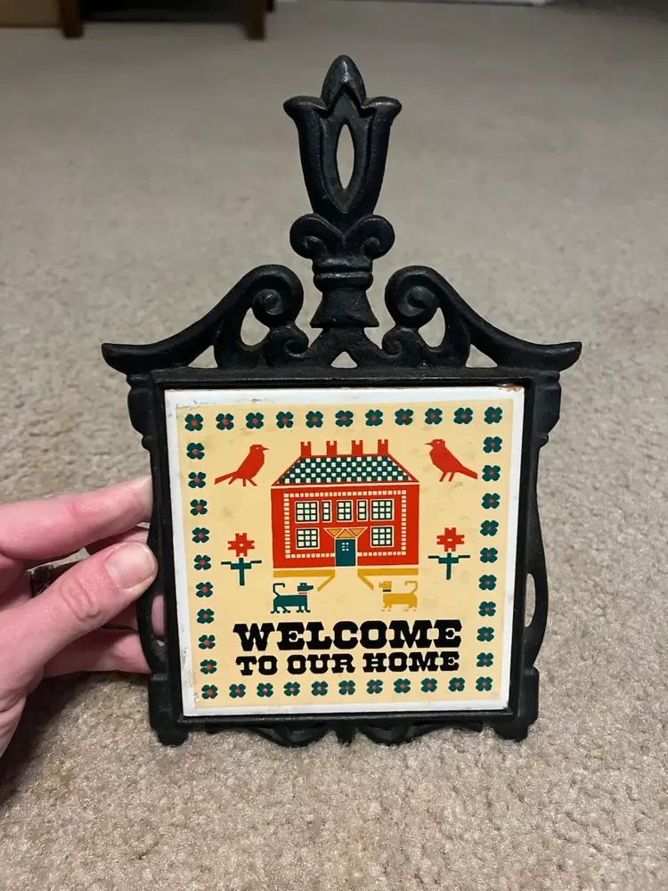 Vintage ceramic and cast iron trivet with a "Welcome to Our Home" design. Sticker On Back - Enesco made in Taiwan Republic of China 8.5” circa 1970s