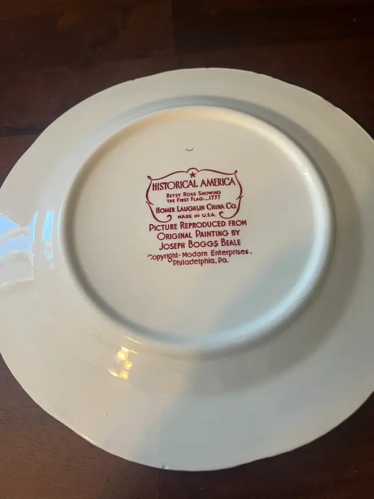 Homer Laughlin red transferware plate depicting Betsy Ross and the American flag. 9”