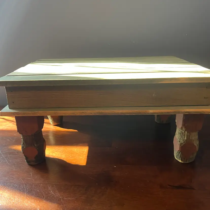 Rustic wooden Riser with carved stump-like legs and plank top. Could be used as a riser top is 13” x 10” stands 6 1/2 inches tall