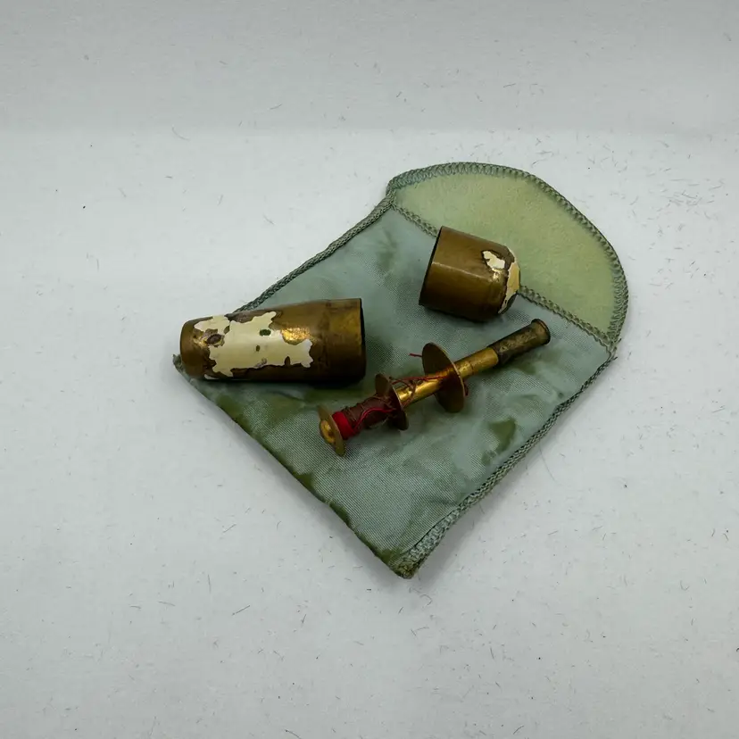 Vintage brass military sewing kit with a fabric pouch