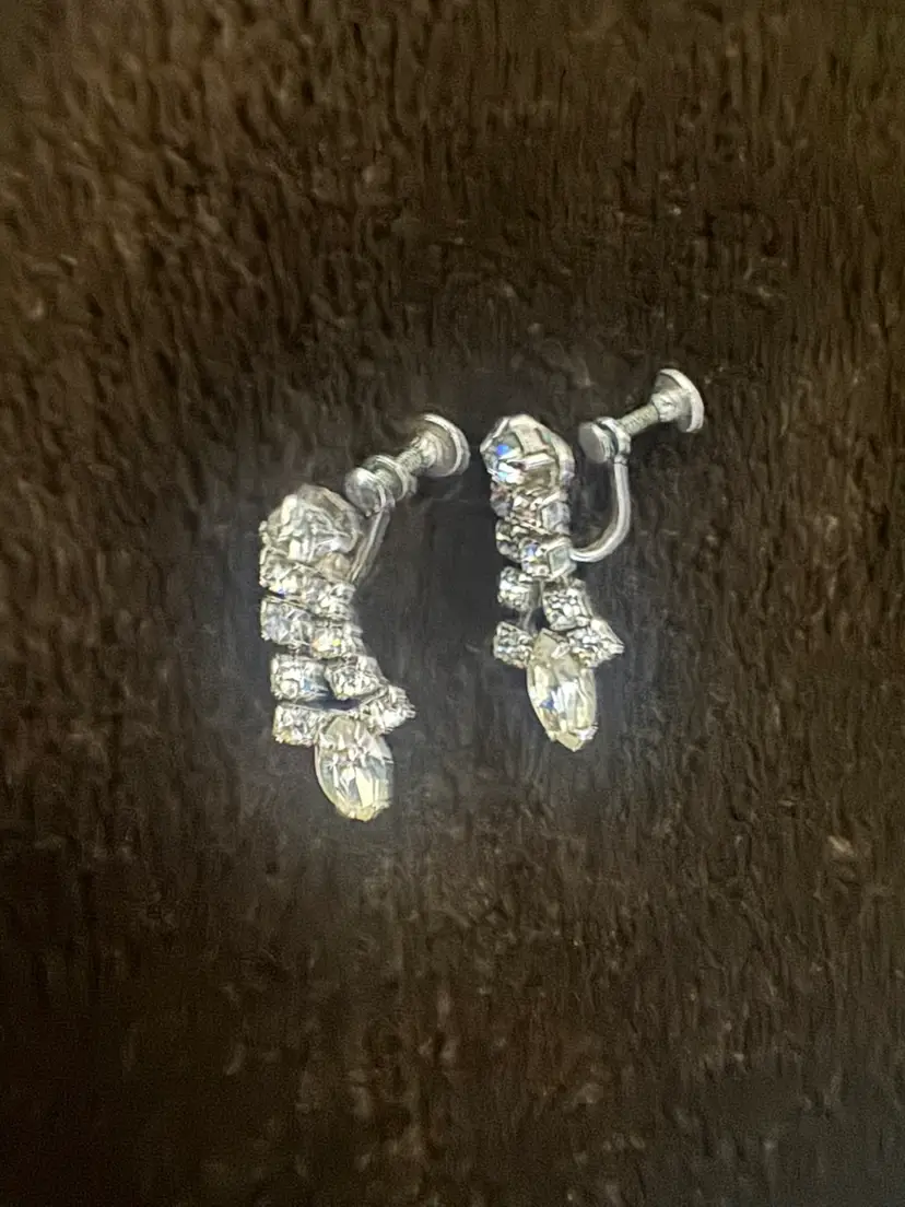 Vintage Continental silver-tone dangle clip-on earrings feature prong-set baguette and round clear rhinestones