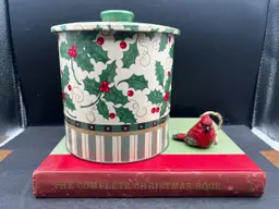 Vignette #5 Includes A Vintage Hard Cover ‘The Complete Christmas Book’
Published By Franklin Watts, Illustrated By William Ronin
A Vintage Christmas Tin. Santa’s Workbench Holly And Berry Pattern
1999 Jo-Ann Stores, Inc.
And An Adorable Cardinal Figurine.