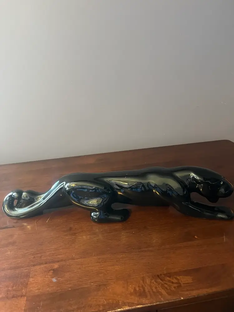 A glossy black ceramic panther figurine in a stalking pose. 19”
