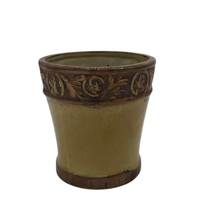 Ceramic planter with two-tone glaze and an embossed scroll design.