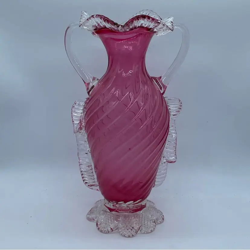 #0424 Art Glass cranberry glass vase with applied handles and ruffled rim.