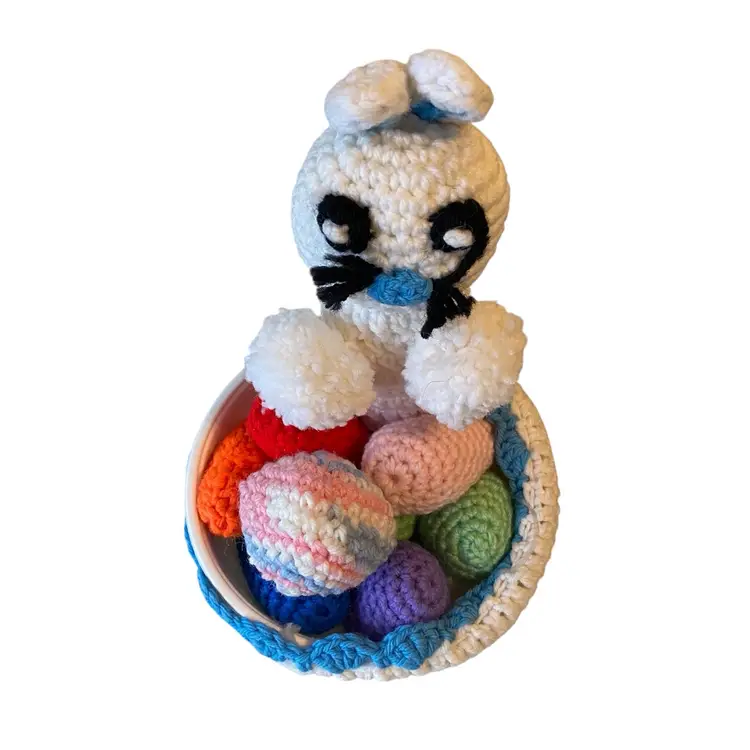 This item is a handmade crochet Easter bunny decoration featuring a basket filled with small colorful eggs