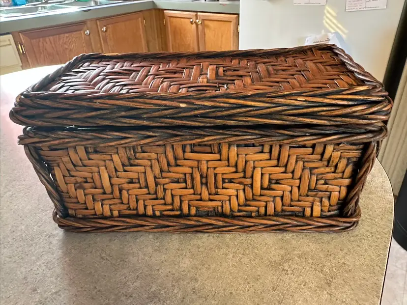 Handwoven wicker storage basket with herringbone pattern.