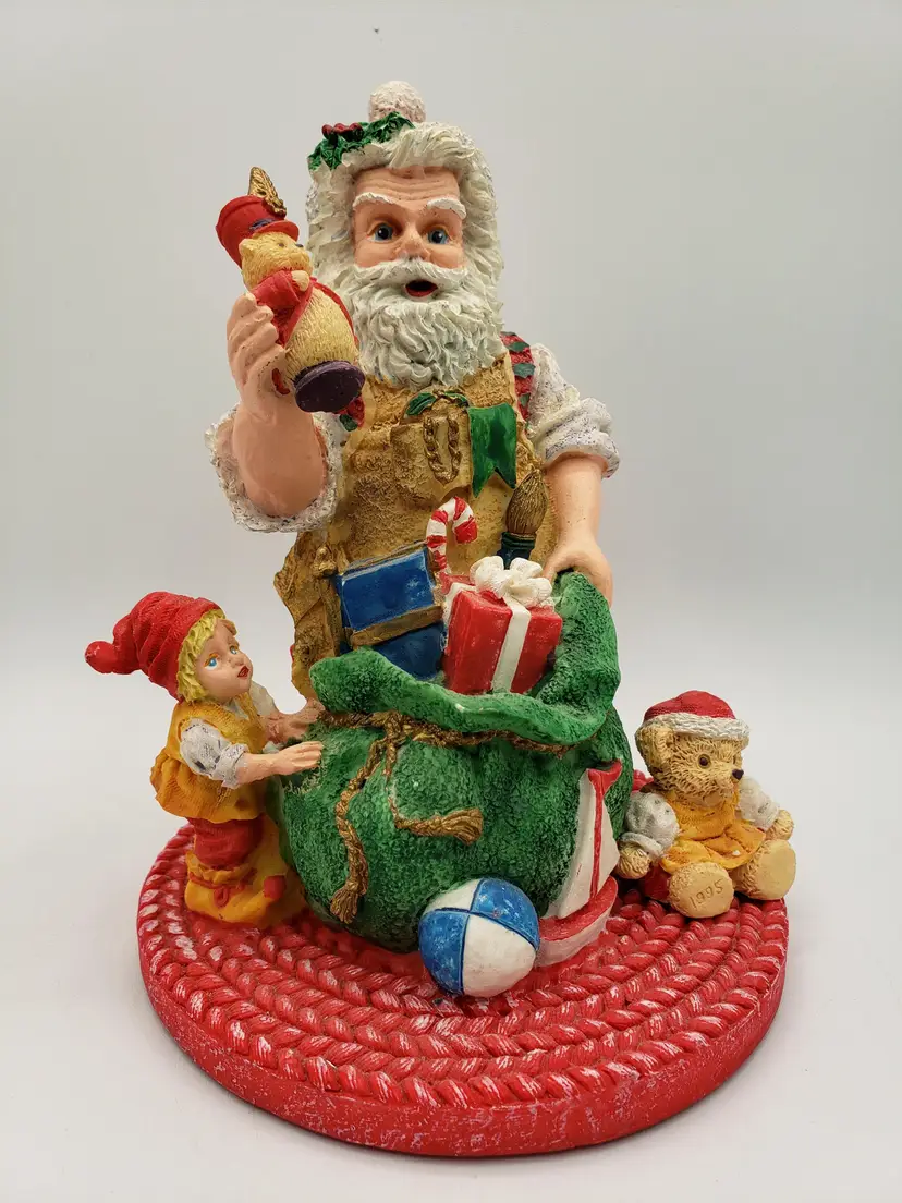 Vintage Christmas Santa's Magical Toyshop KMart Exclusive Decor 1995 Cheryl Ann. Traditional Santa with his bag of toys and cozy, braided rug. Resin.