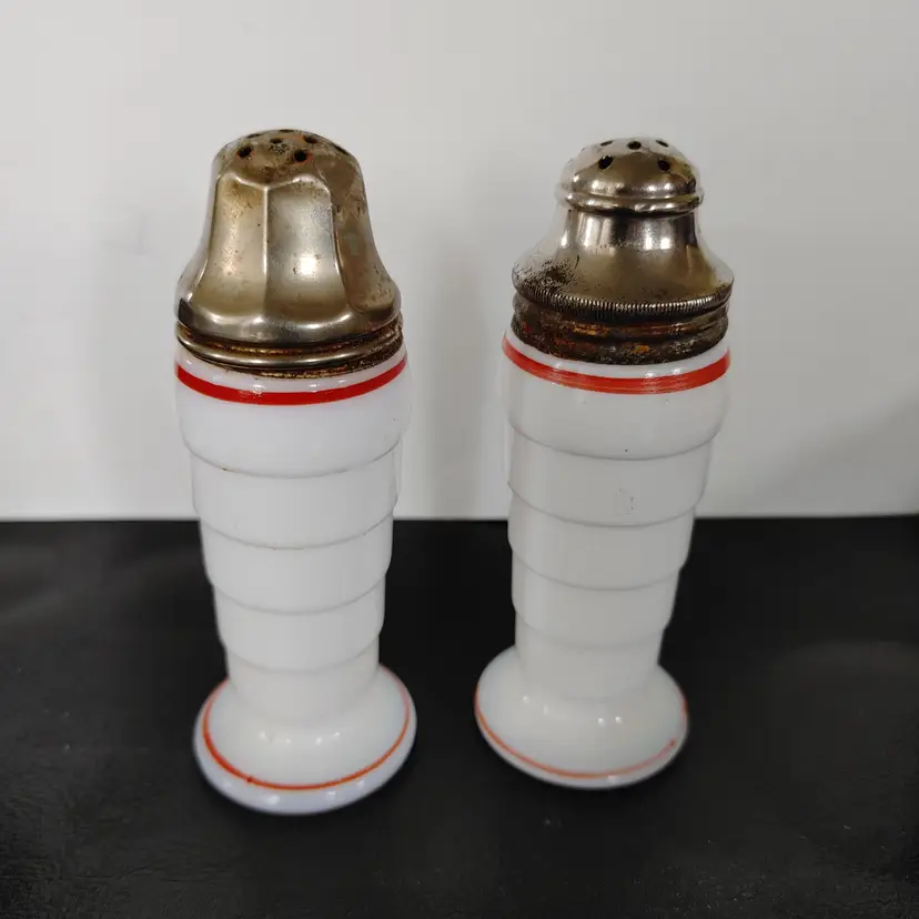 Hazel Atlas Moderntone Platonite milk glass Salt & Pepper Set with Red rim. 4.5 inches high. Chip on 1 shaker lid and bottom rim. See pics. 1930-1940.