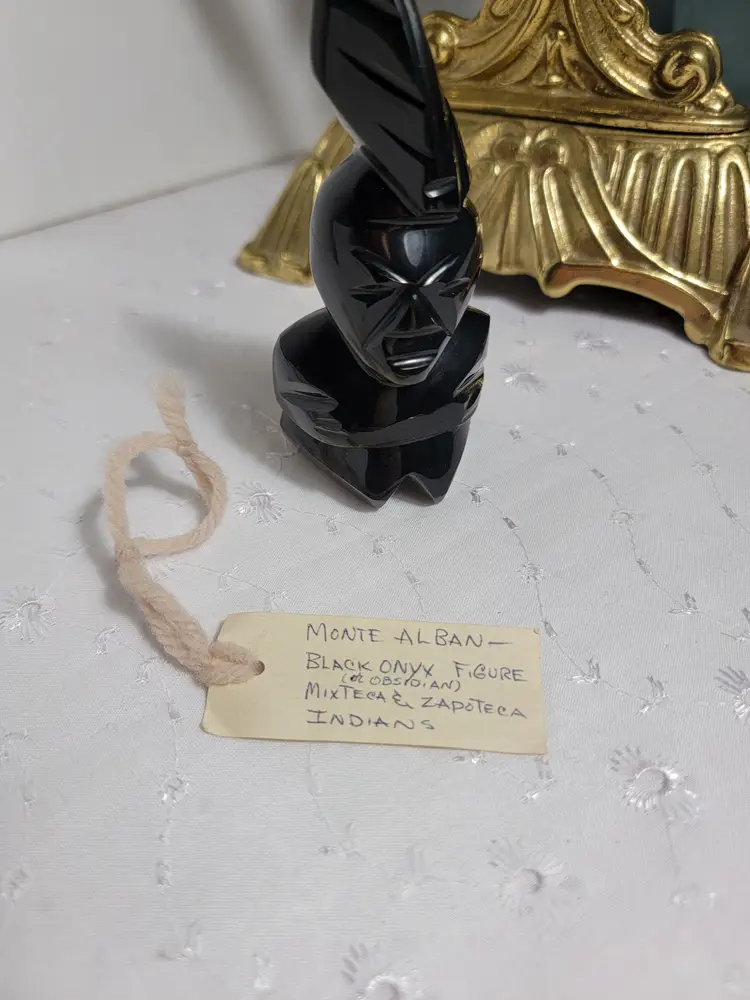 Vintage carved black stone figurine likely made of obsidian
